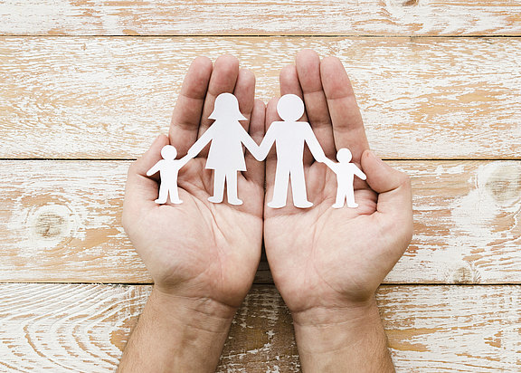 person-holding-paper-family-hands.jpg 